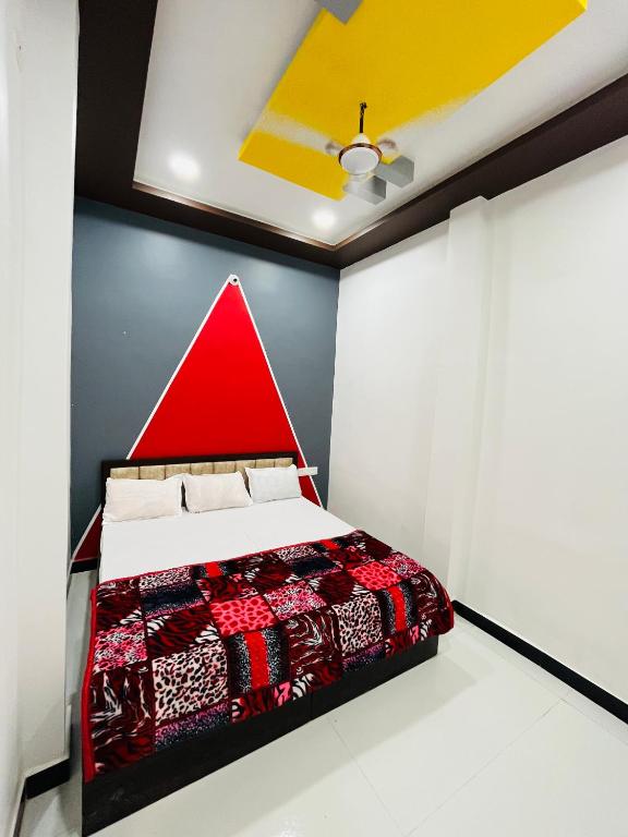 um quarto com uma cama vermelha num quarto em Guru kripa guest house em Ujaim