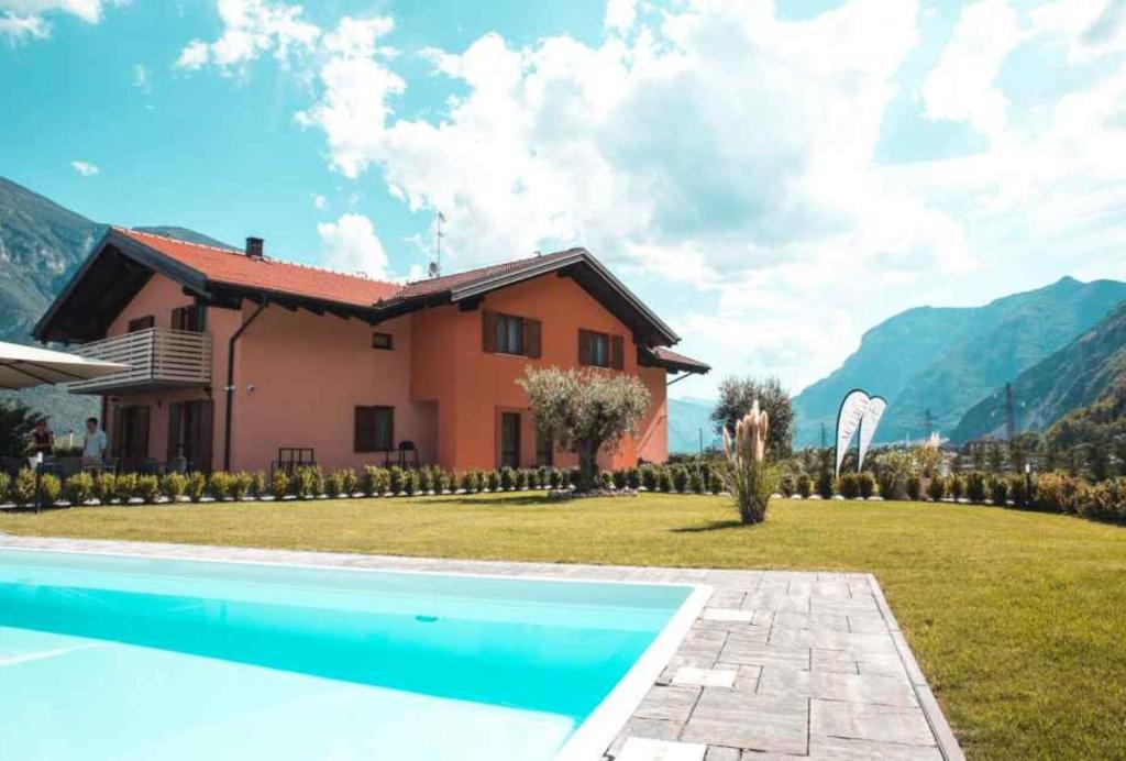 a villa with a swimming pool in front of a house at Agriturismo Maso Miri in Trento