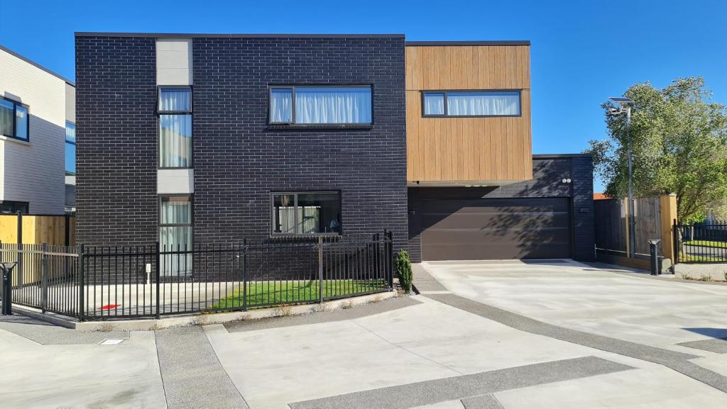 a brick building with a fence in front of it at El Beracca Retreat - 3 bedroom home away from home in Palmerston North
