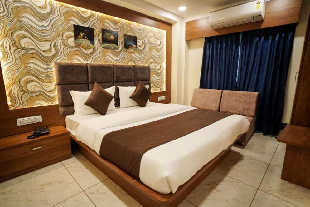 ein Schlafzimmer mit einem großen Bett in einem Zimmer in der Unterkunft Hotel Mahaveer in Ahmedabad