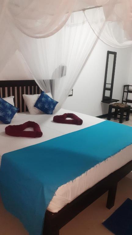 1 Schlafzimmer mit 2 Betten mit blauer und weißer Bettwäsche in der Unterkunft Lake Wind in Habarana
