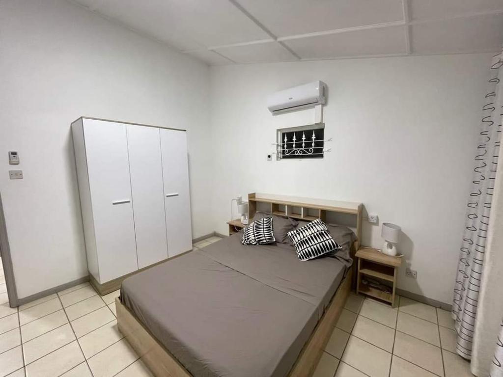 - une chambre avec un lit et un mur blanc dans l'établissement 23 Residence Thalassa,, à Belle Mare