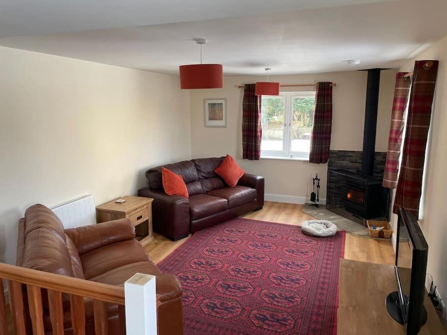 a living room with a leather couch and a red rug at The Old Milk House in Richmond