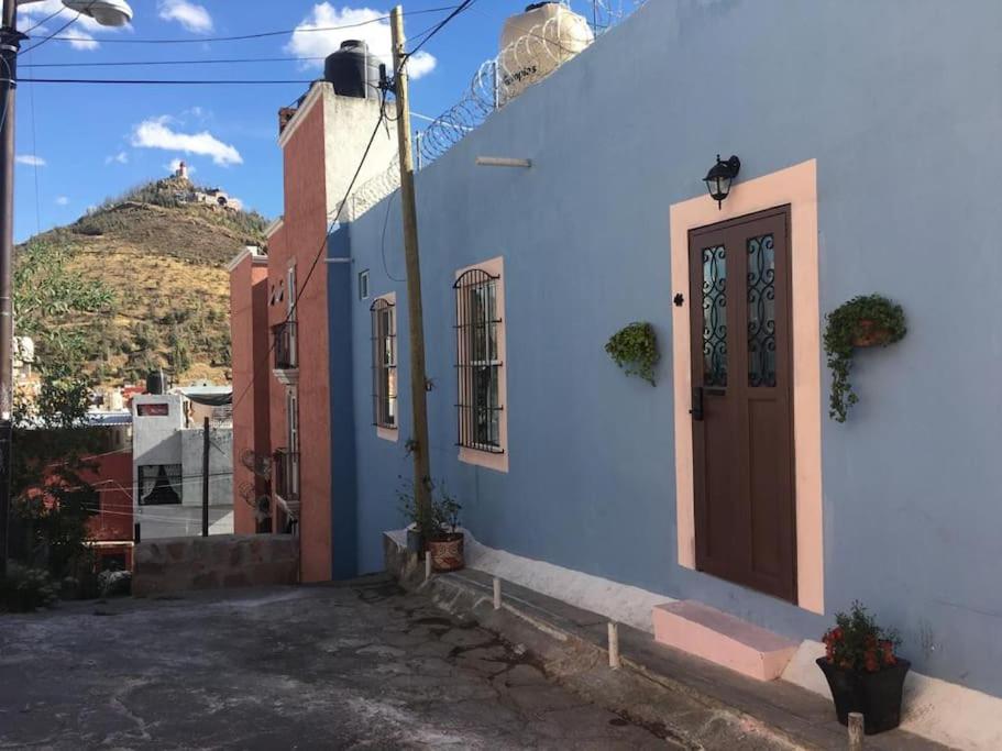um edifício azul com uma porta e uma montanha em New house in historic center, close to amenities. em Zacatecas