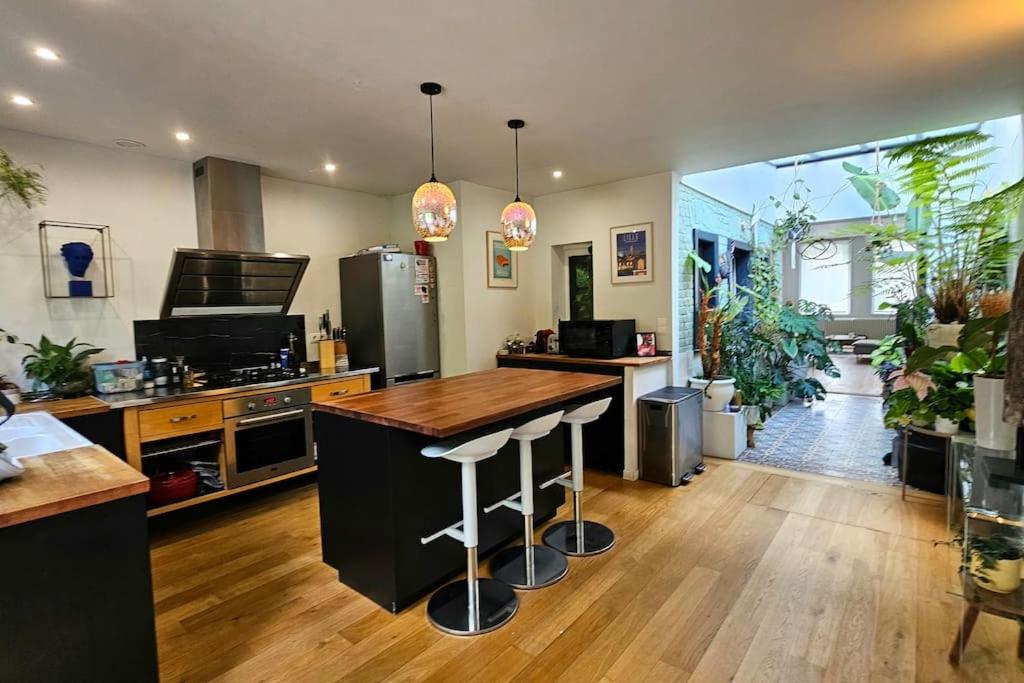 a kitchen with a bar with stools in it at Maison de Caractère 8 pers - Jardin - in Lambersart