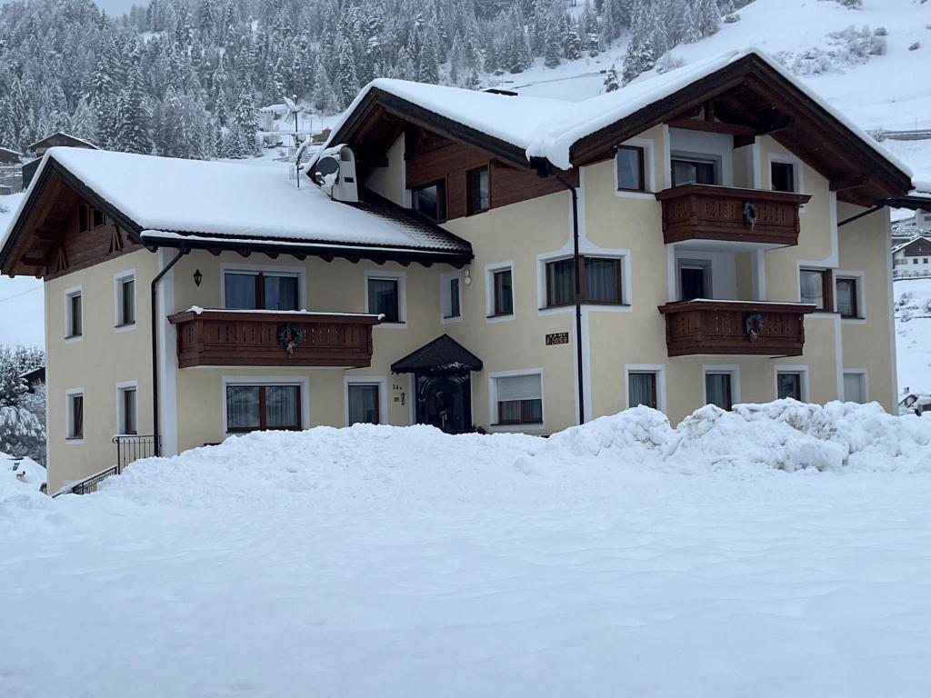 een groot huis met sneeuw ervoor bij A Sosta in Selva di Val Gardena