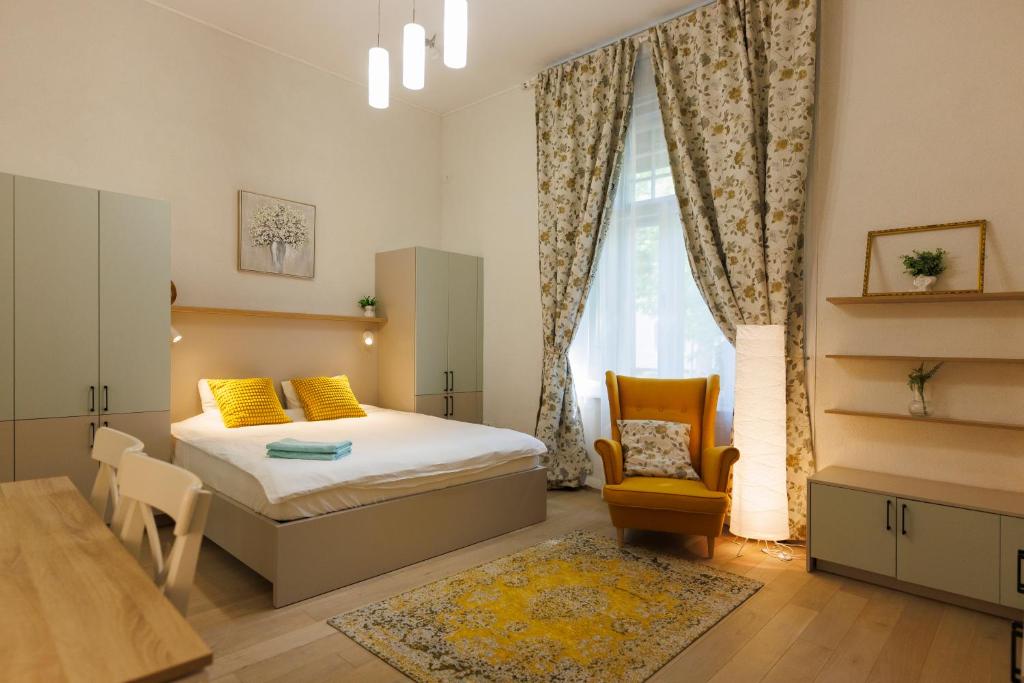 a bedroom with a bed and a table and a chair at Victoriei Square Apartment in Timişoara