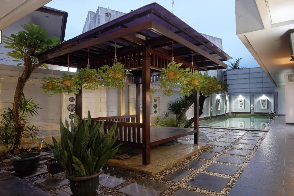 un pavillon avec un banc au milieu d'un bâtiment dans l'établissement ARCS House Pakubuwono by Jambuluwuk, à Jakarta