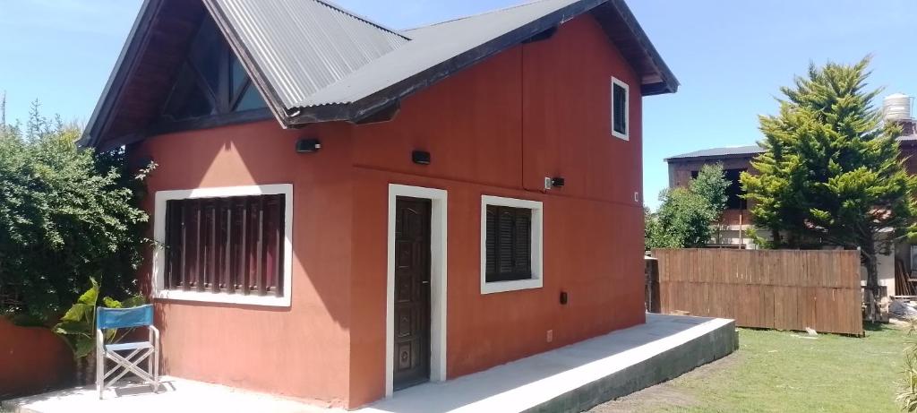 una pequeña casa roja con techo negro en Casa en el faro sona sur asta 5 plazas en Mar del Plata