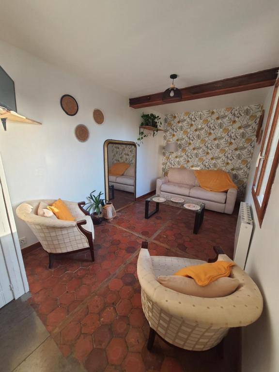 a living room with chairs and a couch and a mirror at La Maison Nasona in Bresles