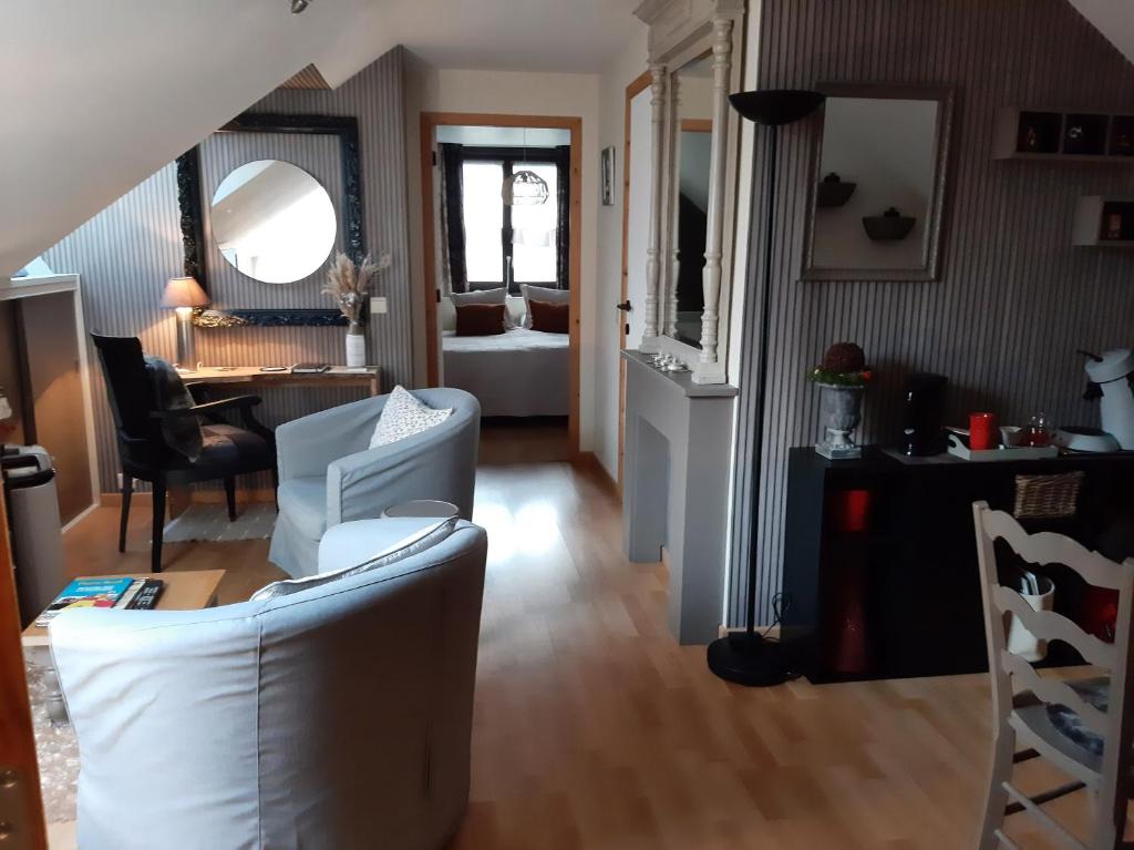 ein Wohnzimmer mit einem weißen Sofa und einem Tisch in der Unterkunft Reve gourmand in Beauraing