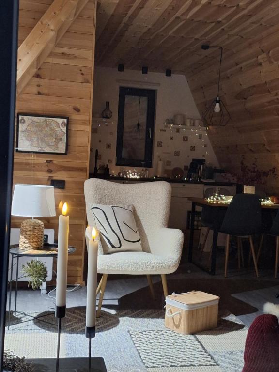 ein Wohnzimmer mit einem Stuhl und 2 Kerzen in der Unterkunft Zibran Cabane in Bran