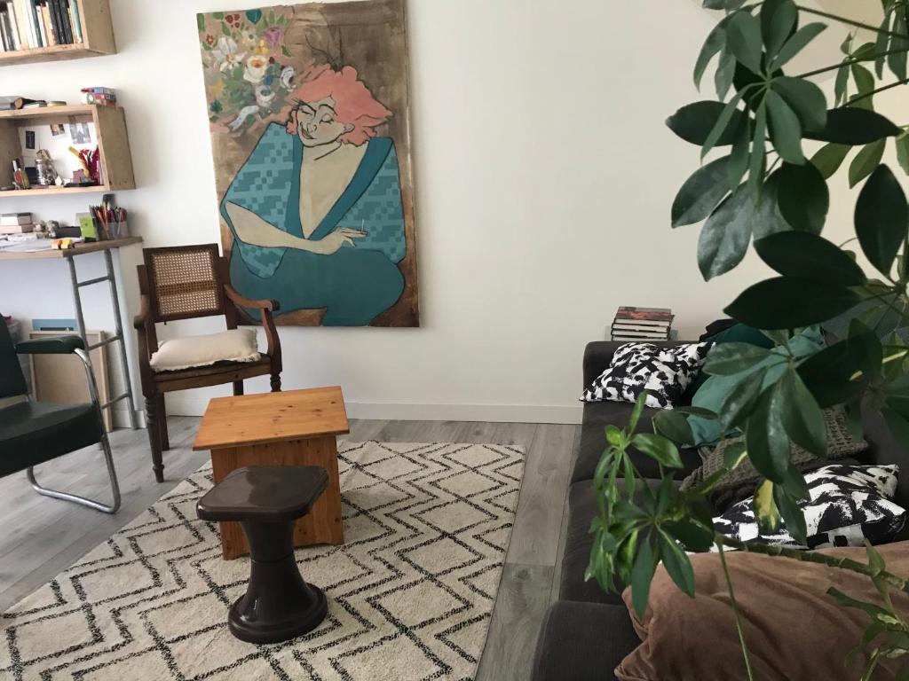 a living room with a painting of a woman on the wall at LE NID in Saint-Jean-de-la-Porte