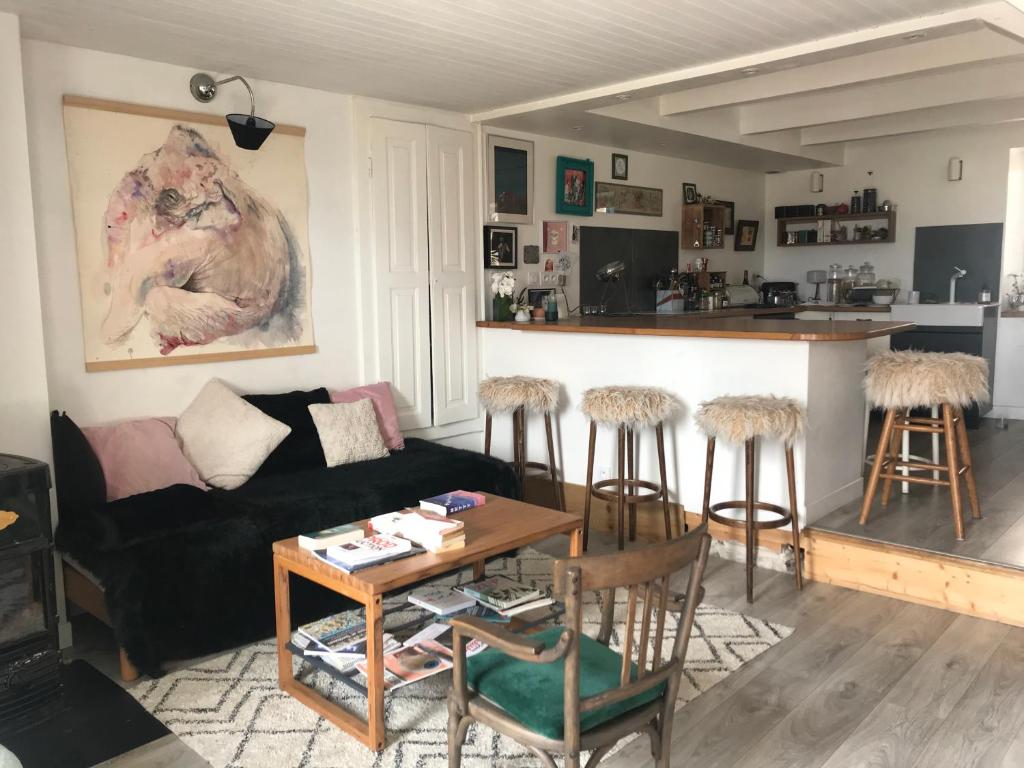 a living room with a couch and a table and a kitchen at LE NID in Saint-Jean-de-la-Porte