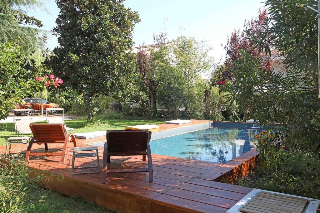 twee stoelen op een terras naast een zwembad bij Il Bozzolo Eco Boutique Apartments in Valeggio sul Mincio