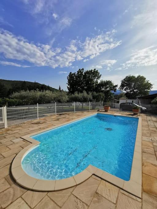une grande piscine bleue sur une terrasse dans l'établissement La Baraquette Cévenole, à Laroque
