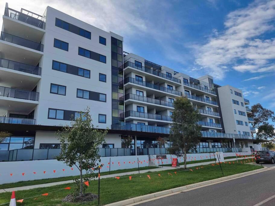 a large white apartment building on the side of a street at Gungahlin Center-1 Bedroom New Stylish Unit in Harrison