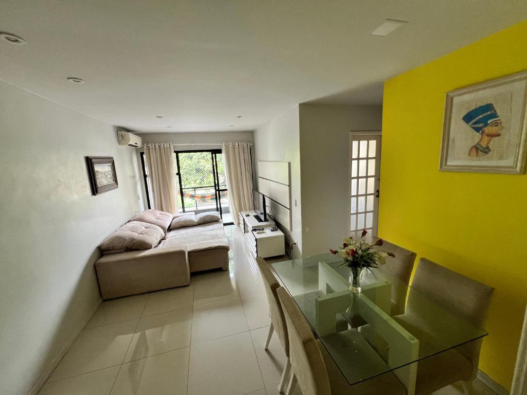 um quarto com uma cama e uma parede amarela em Apartamento Área Nobre no Recreio dos Bandeirantes no Rio de Janeiro