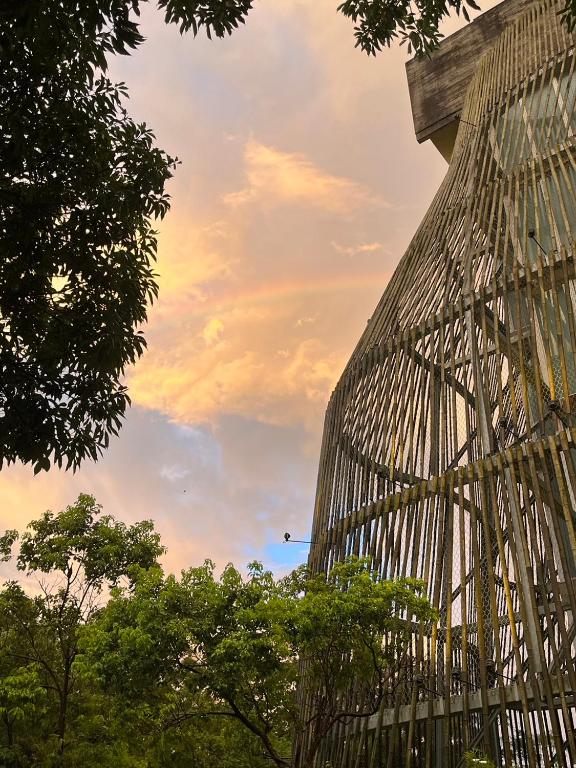 a tall building with trees in front of a cloudy sky at 了了礁溪 Vivir Jiaoxi Hotel in Jiaoxi