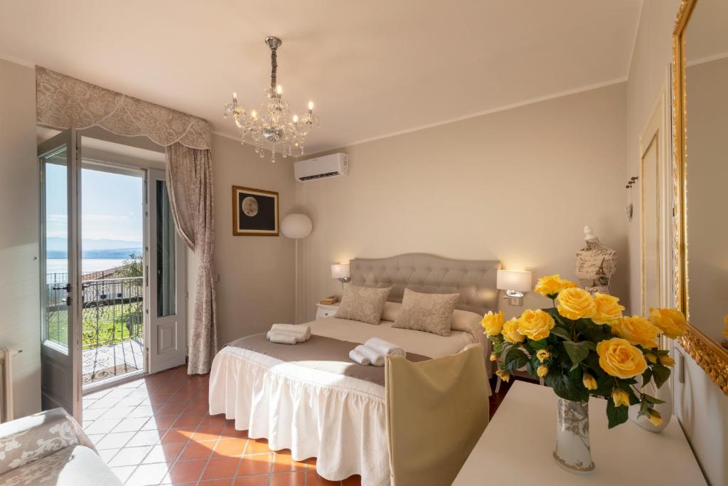 a bedroom with a bed and a vase of yellow flowers at Il Torrione in Castiglione del Lago