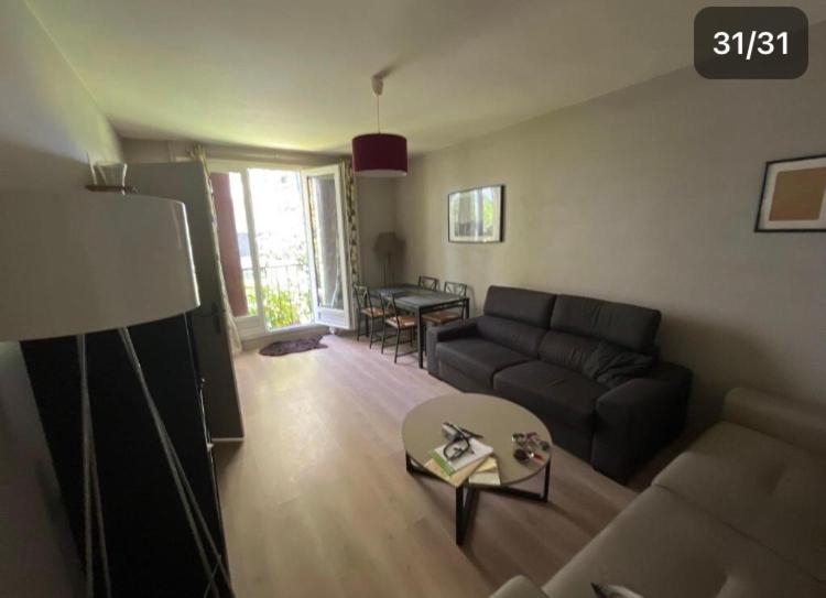a living room with a couch and a table at Pavillon Tawfik 1 à 4 personnes chez l’habitant in Bagneux