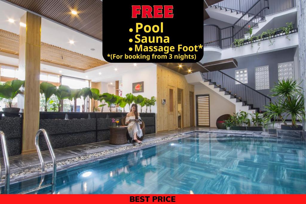 岘港King House Villa Hotel & Spa的坐在酒店游泳池旁的女人