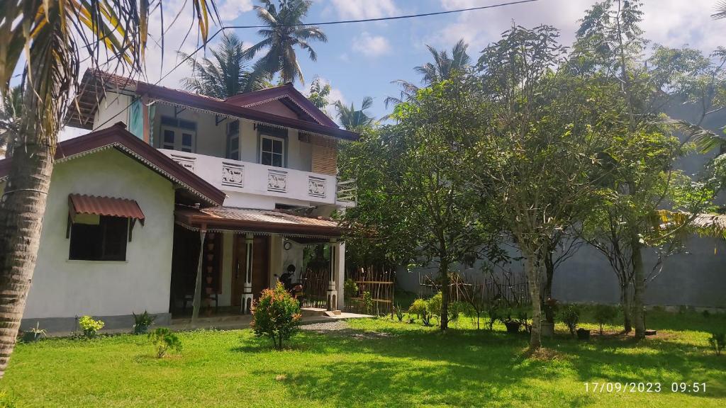 a house with trees in front of it at Green House, Upstairs Apartment in Madihe East