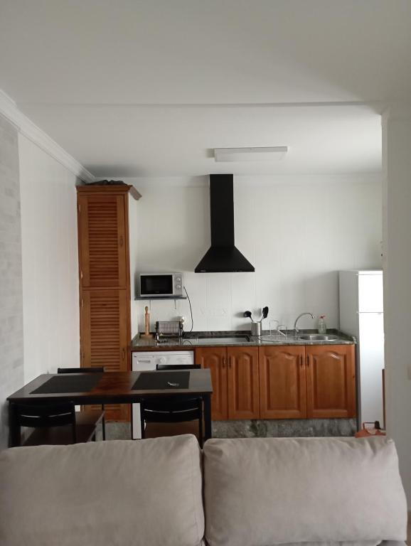 uma sala de estar com uma mesa e uma cozinha em El 20 em Barbate
