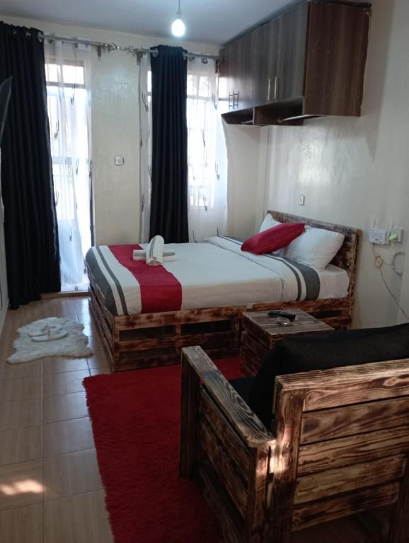 a bedroom with two beds and a red rug at Cozy furnished studio in Nairobi