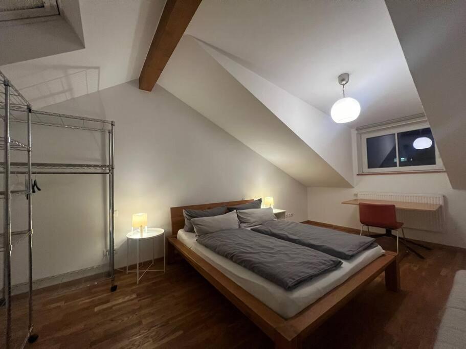 Schlafzimmer mit einem Bett, einem Schreibtisch und einem Fenster in der Unterkunft Charmantes Loft in der Bayreuther City in Bayreuth