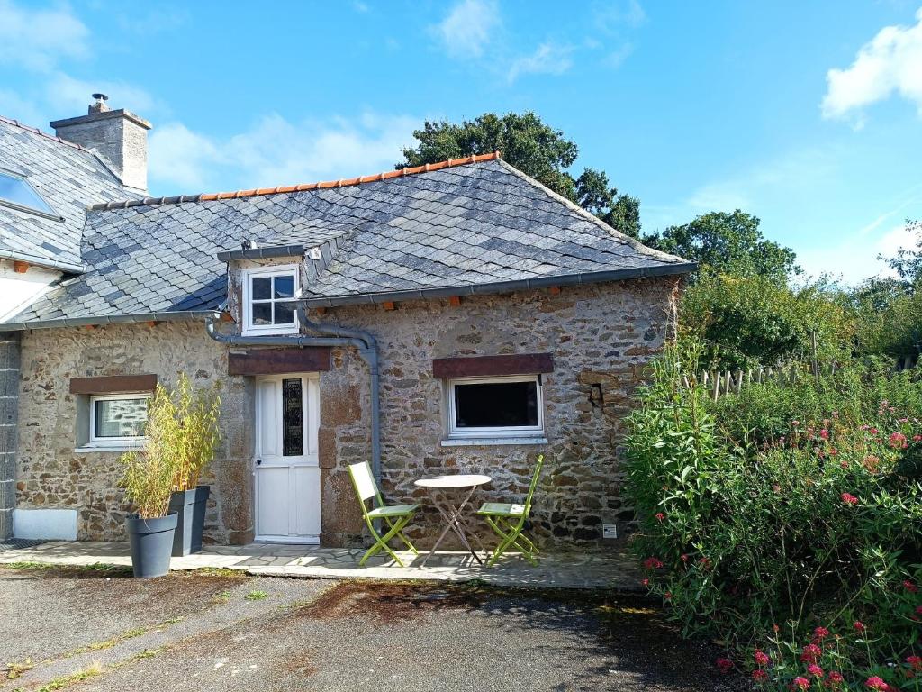 une maison en pierre avec une table et des chaises à l'extérieur dans l'établissement Maison studio proche mer, à Pordic