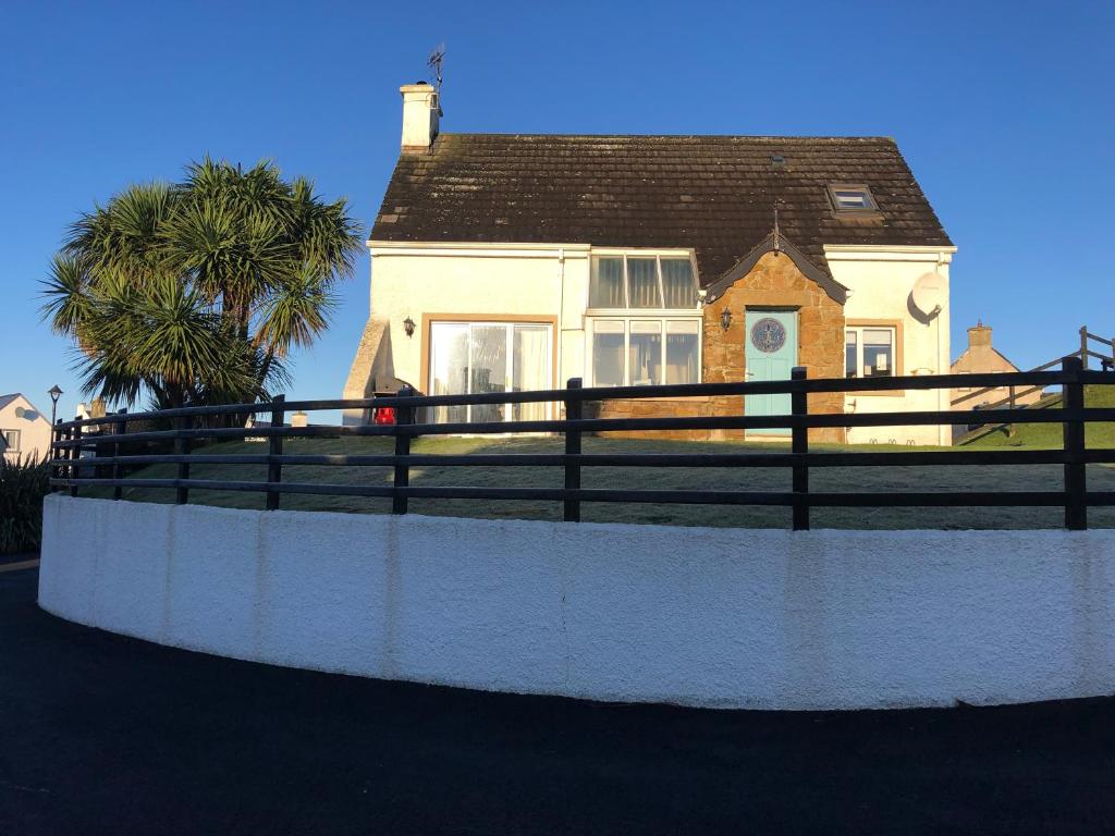 a house with a fence in front of it at Rossnowlagh Beach House in Donegal