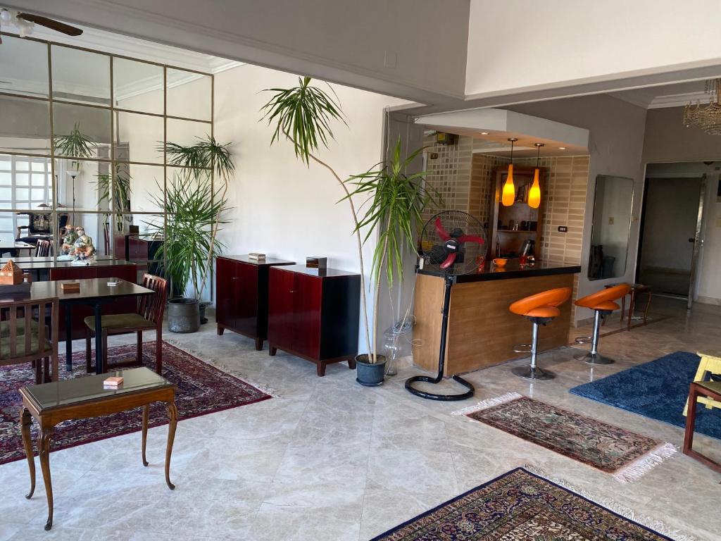 una sala de estar con mesas, sillas y plantas. en GIZA NILE VIEW APT en El Cairo