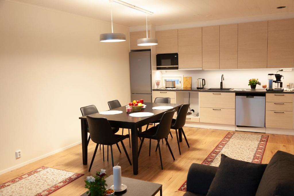 a dining room and kitchen with a table and chairs at Saimaan Kodikas A3 in Savonlinna