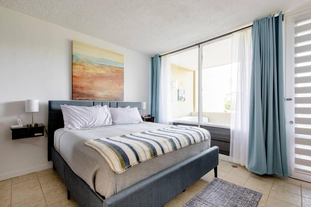 a bedroom with a bed and a large window at Carey Beach Villa in Humacao