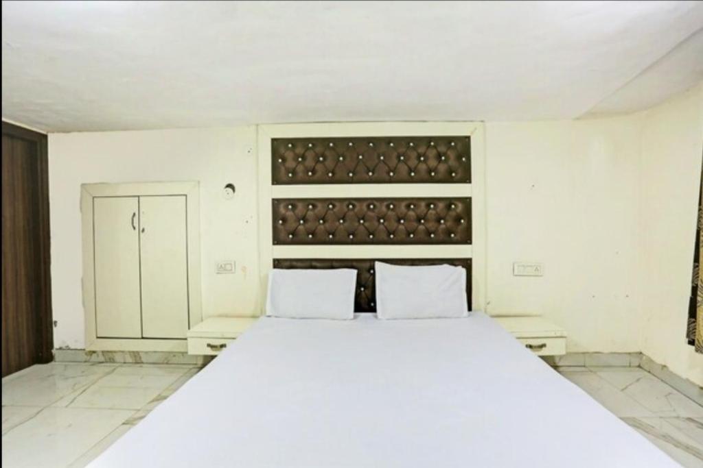 um quarto com uma grande cama branca e 2 almofadas em Mishra residency em Amritsar