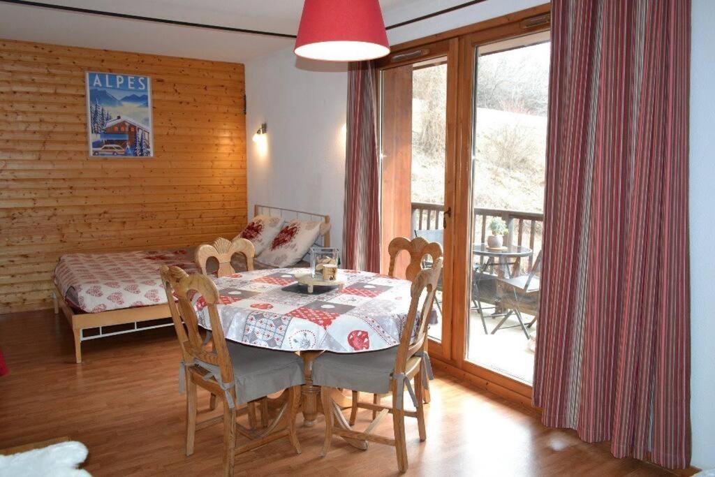 une salle à manger avec une table et des chaises et un balcon dans l'établissement Orelle 3 vallées Studio 2 p, à Orelle