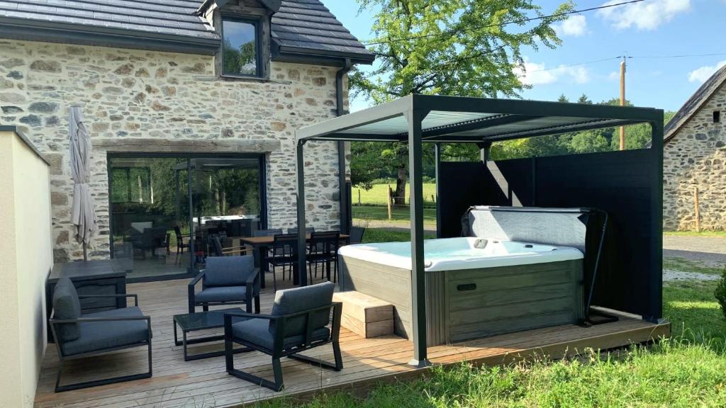 einen Whirlpool unter einem Pavillon auf einer Terrasse in der Unterkunft Gîte Le Chambougeal in Lagraulière