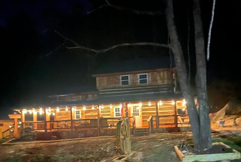 een houten hut 's nachts met verlichting bij Jewel Branch Cabin in Erwin
