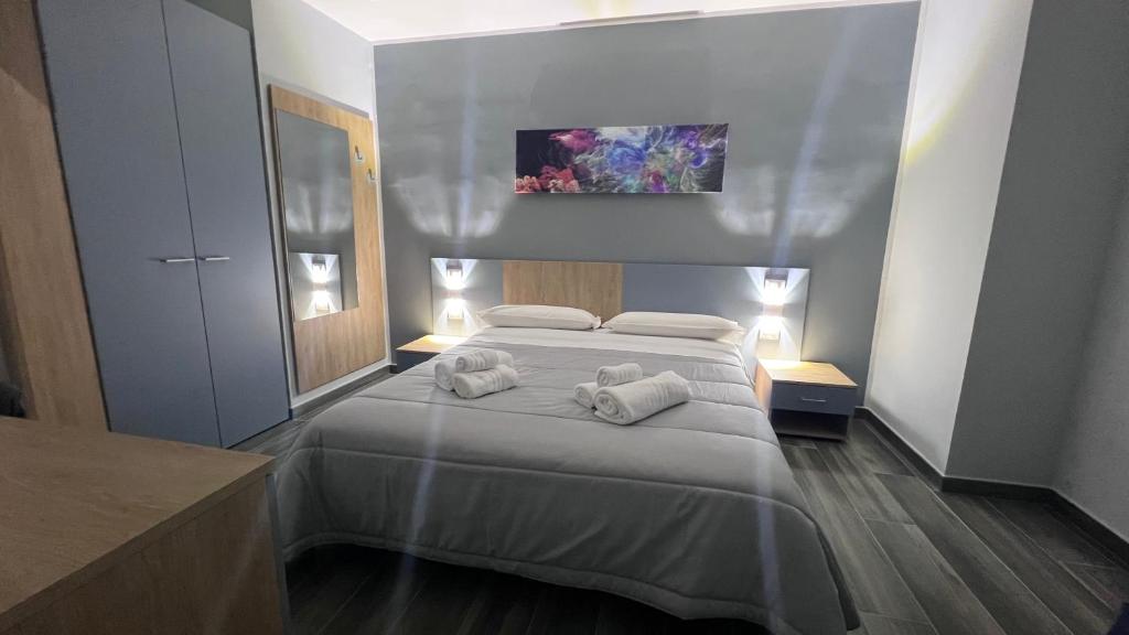 una camera da letto con un letto e asciugamani di ALMA B&B Cosenza CENTRO a Cosenza