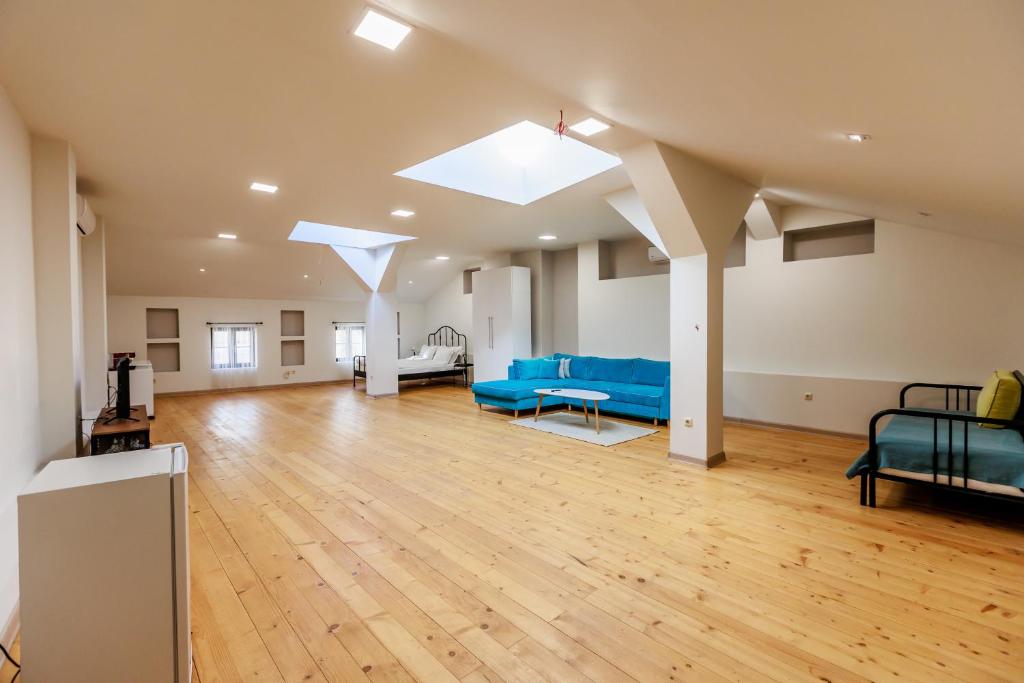 una grande camera con divani blu e pavimento in legno di B4 XL Studio Saffron a Plovdiv