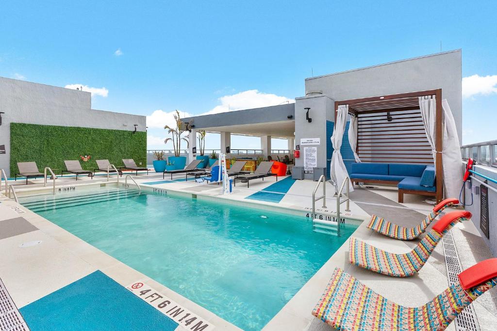 uma piscina com espreguiçadeiras e um resort em Aloft Fort Lauderdale Airport em Fort Lauderdale