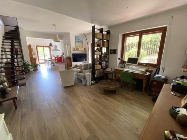 ein großes Wohnzimmer mit Holzboden und einem Schreibtisch in der Unterkunft Francigena house in Rom