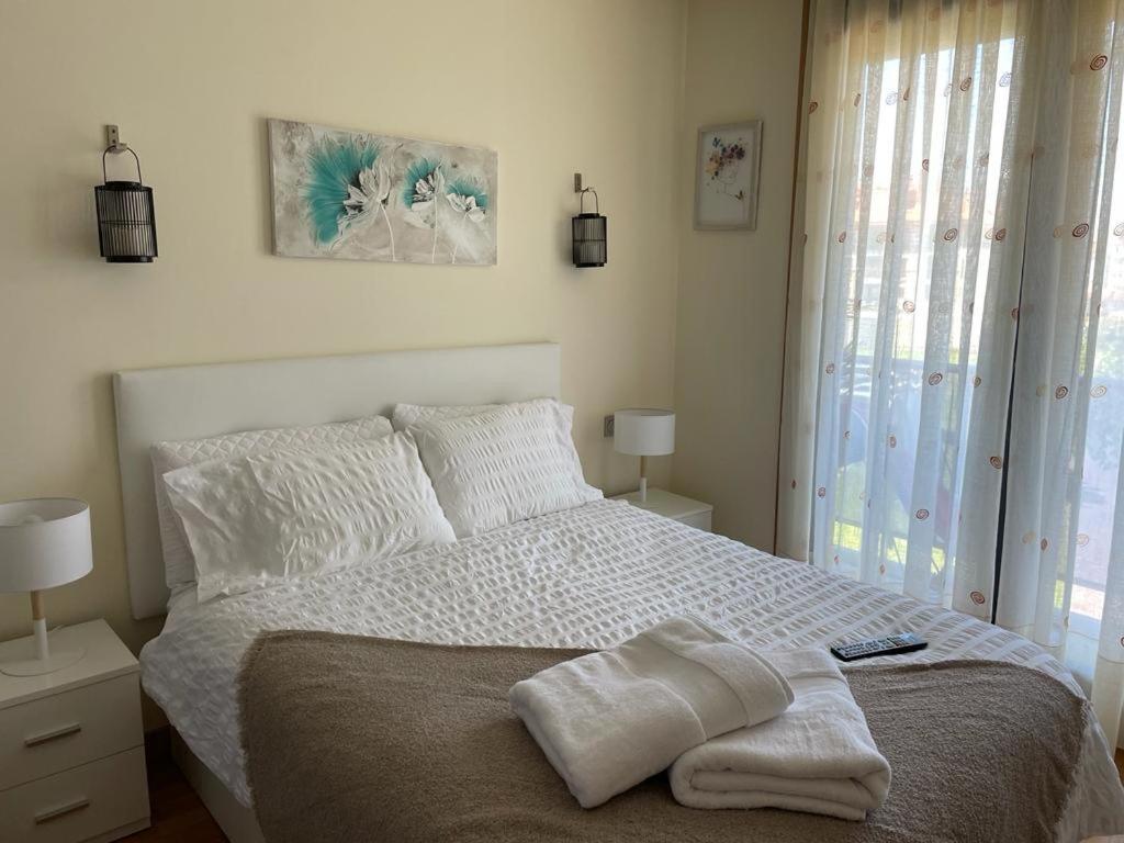 a white bedroom with a bed with a blanket on it at Recuncho Costeiro in Baiona