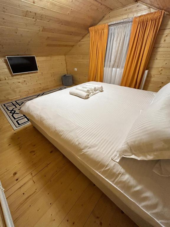 a bedroom with a large bed in a wooden room at Cabana EviMat Azuga in Azuga