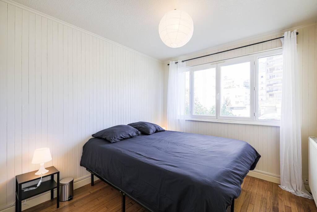 a bedroom with a blue bed and a window at T4 spacieux tout confort &#47; parking gratuit in Grenoble