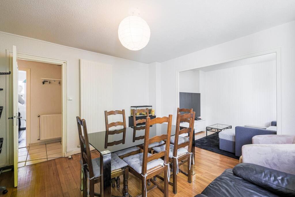 a living room with a dining room table and chairs at T4 spacieux tout confort &#47; parking gratuit in Grenoble