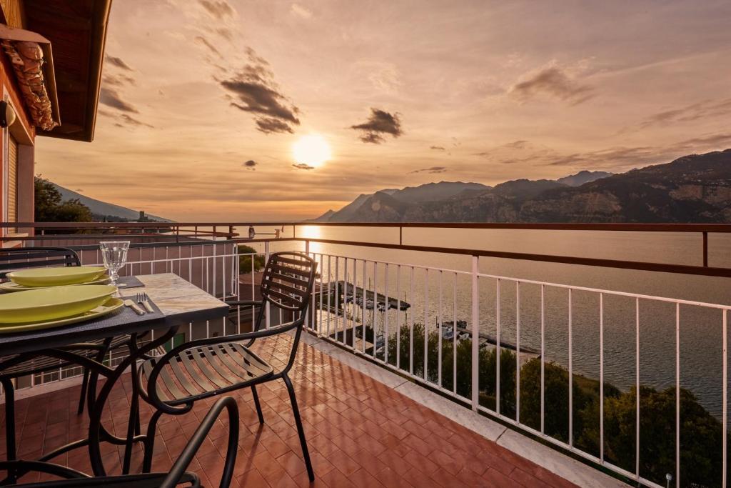 d'un balcon avec des tables et des chaises et une vue sur l'eau. dans l'établissement Lake View Luca Apartment, à Malcesine