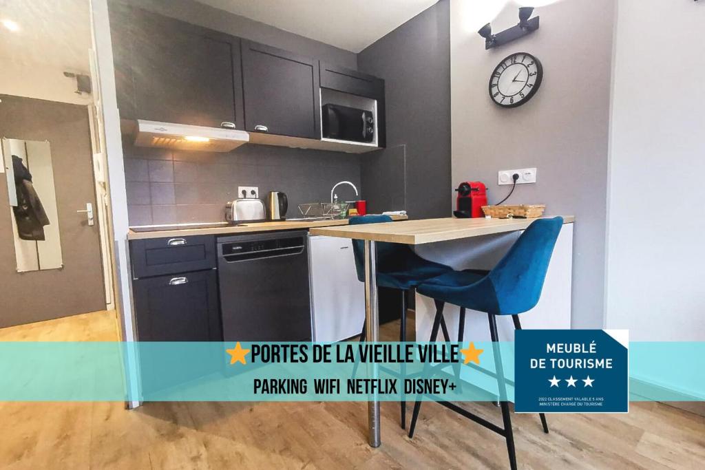 une cuisine avec une table et une horloge au mur dans l'établissement Portes de la vieille ville, à Annecy