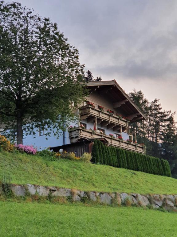 una casa sentada en la cima de una colina verde en Pension Schlossberg, en Mittersill